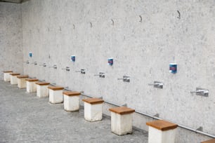 Una fila de bancos de madera sentados junto a una pared