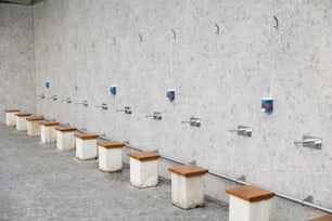 a row of wooden benches sitting next to a wall