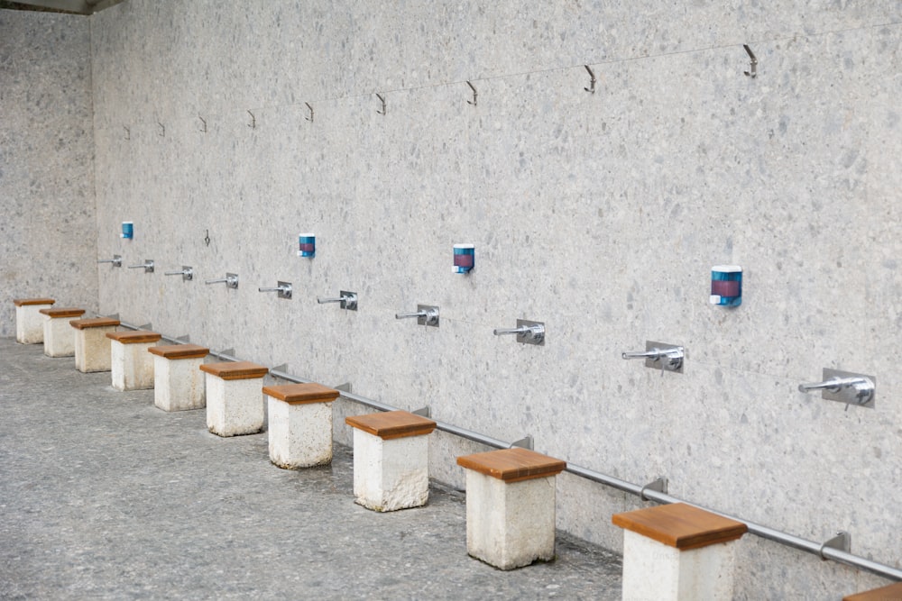 a row of wooden benches sitting next to a wall