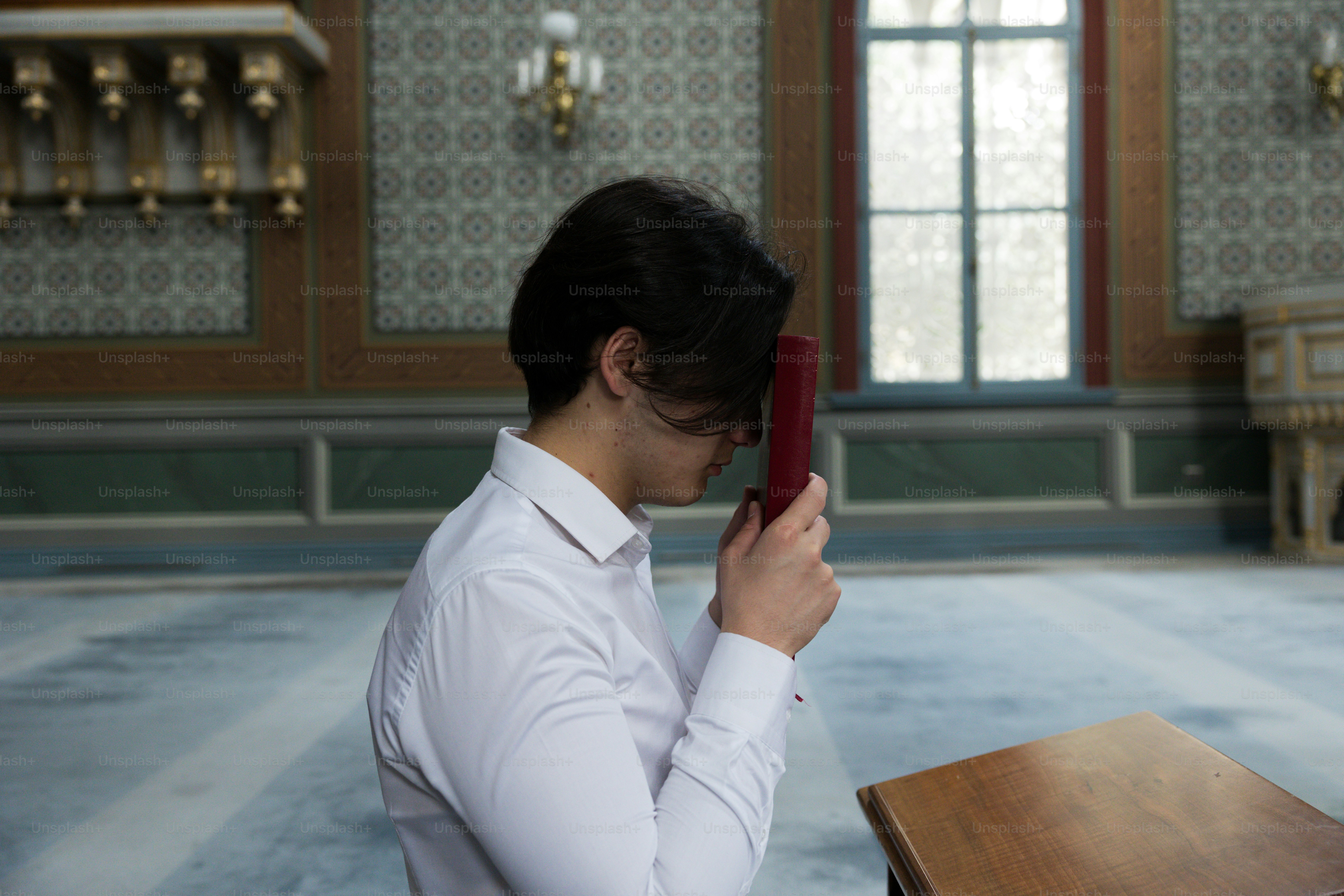a woman in a white shirt is holding a red object