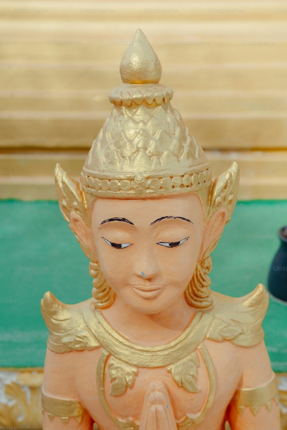 a statue of a buddha with a gold crown on it's head