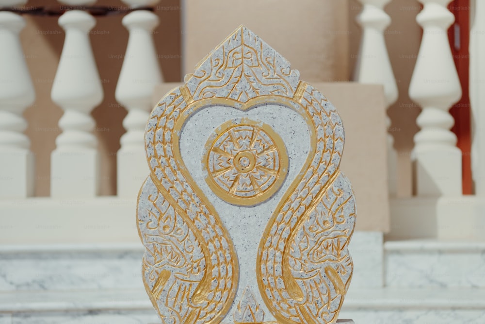 Una escultura blanca y dorada sobre un pedestal de mármol