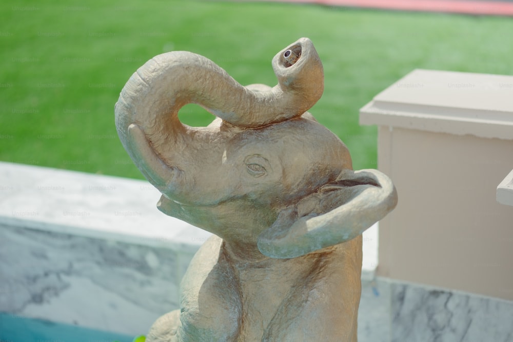 Una estatua de un elefante está al lado de un buzón