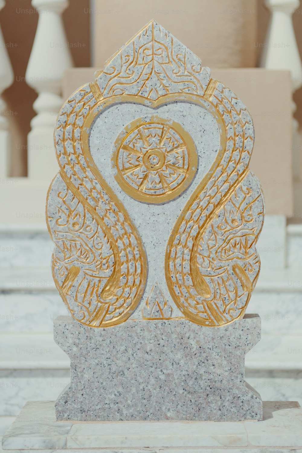 uma estátua de mármore com um design de ouro sobre ele