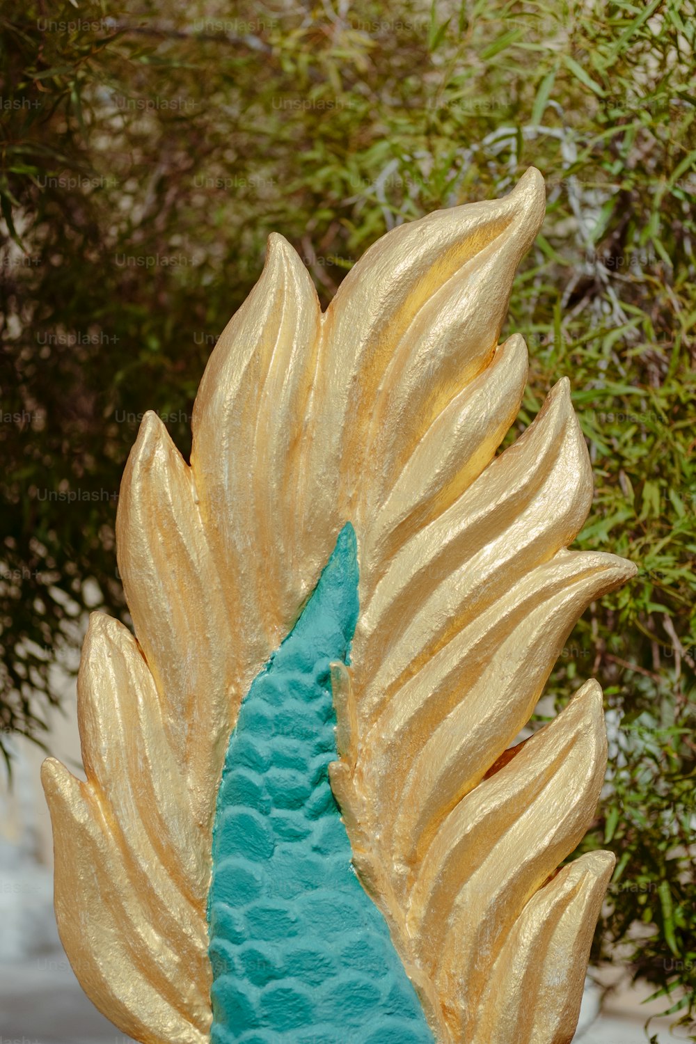a blue and gold statue of a peacock