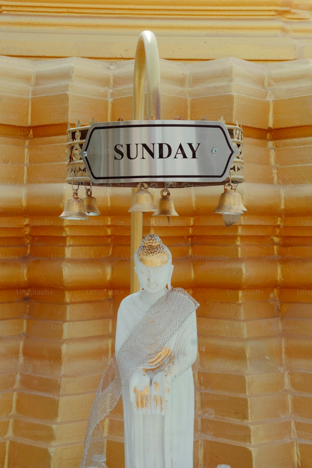 a statue of a person under a street sign