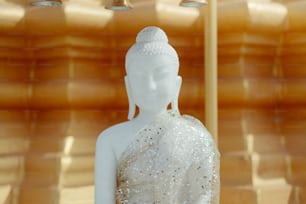 Eine weiße Buddha-Statue sitzt in einem Raum