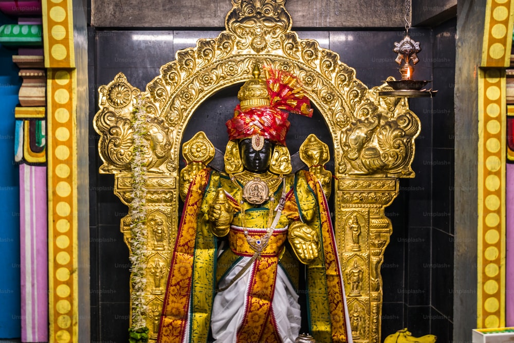 Eine Statue eines Mannes in einem goldenen Outfit