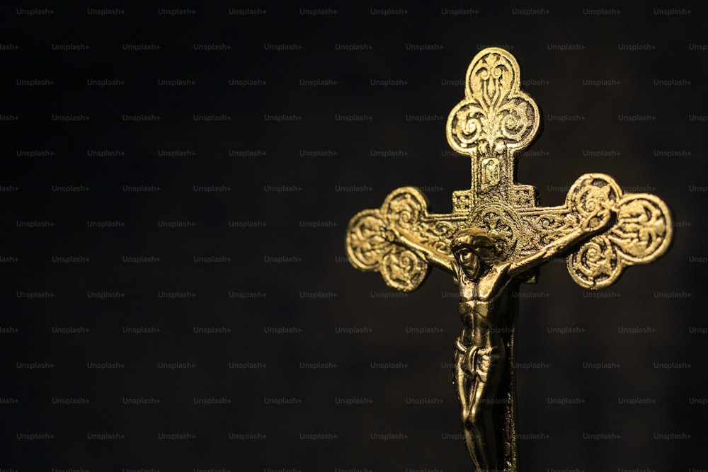 um crucifixo dourado em um fundo preto