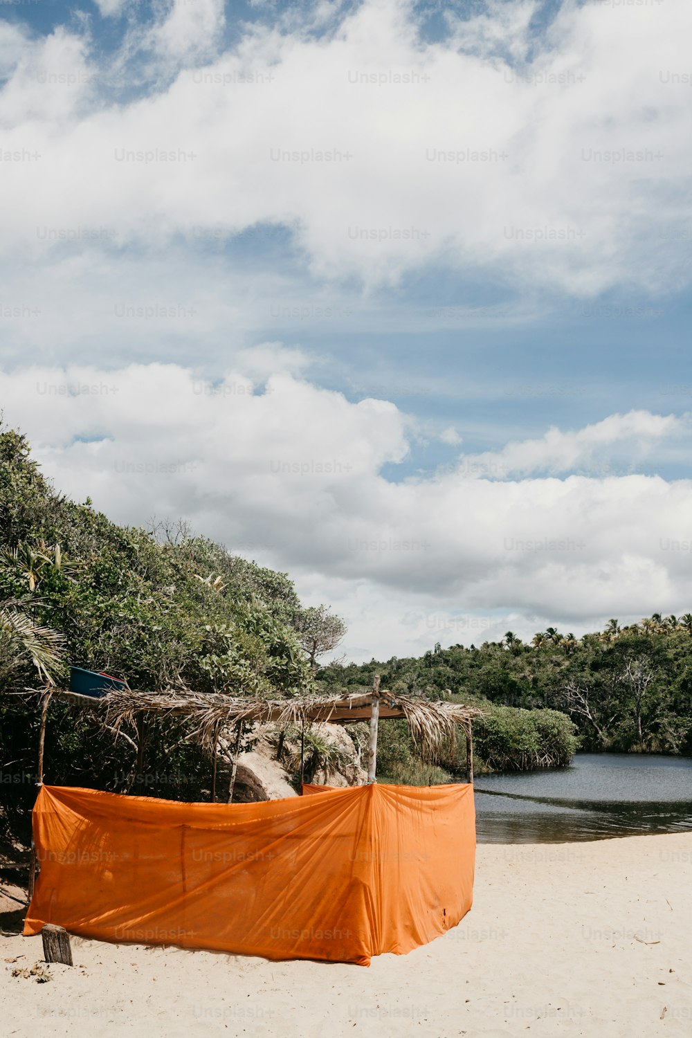 an orange tarp covering a boat on a beach