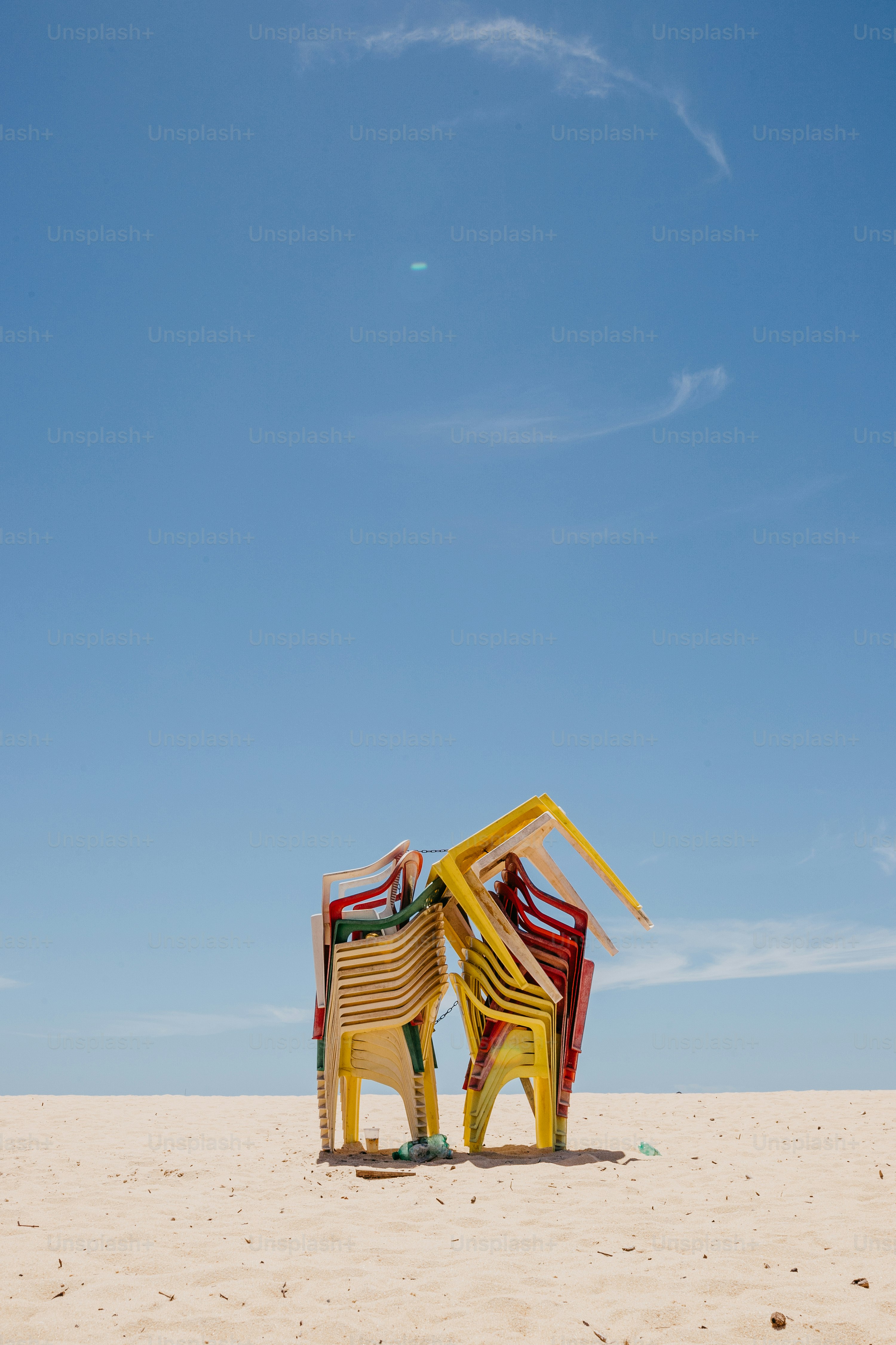 a couple of chairs sitting on top of a sandy beach