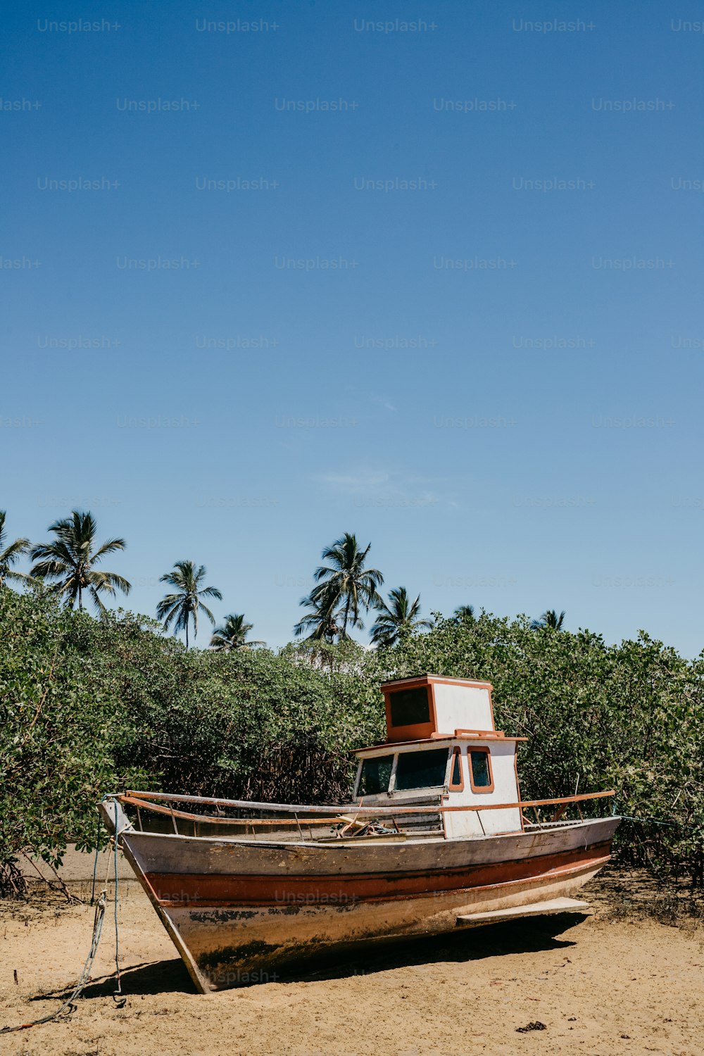 um barco sentado no topo de uma praia de areia