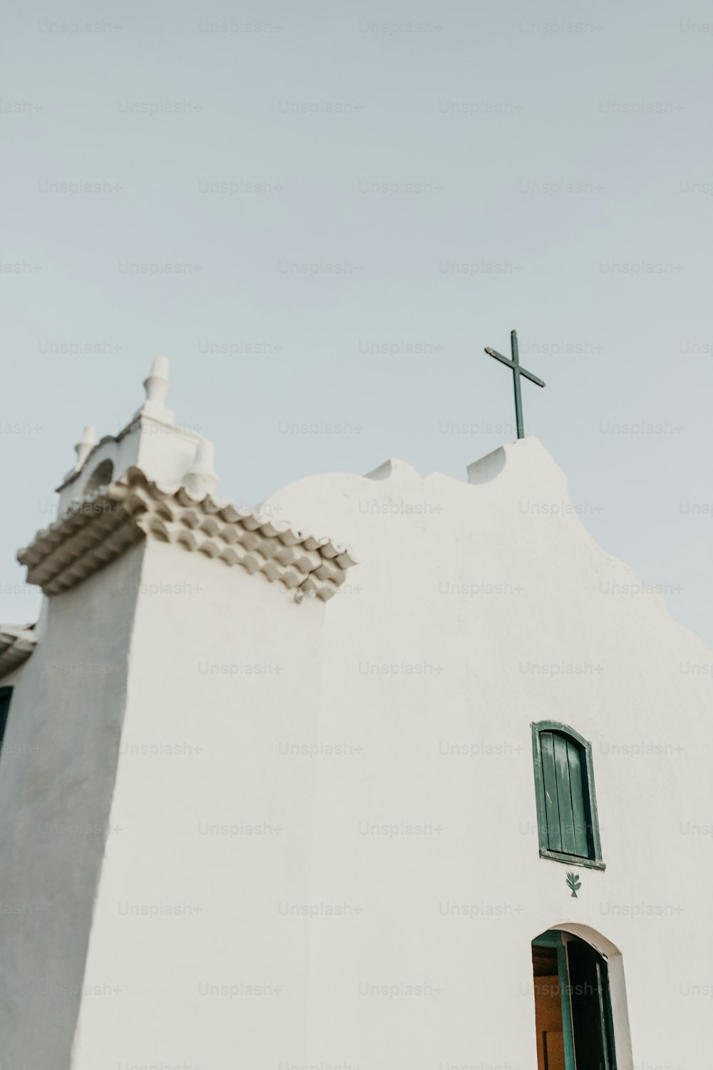 uma igreja branca com uma cruz em cima dela