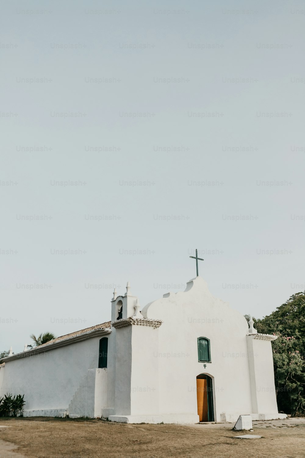 uma igreja branca com uma cruz em cima dela