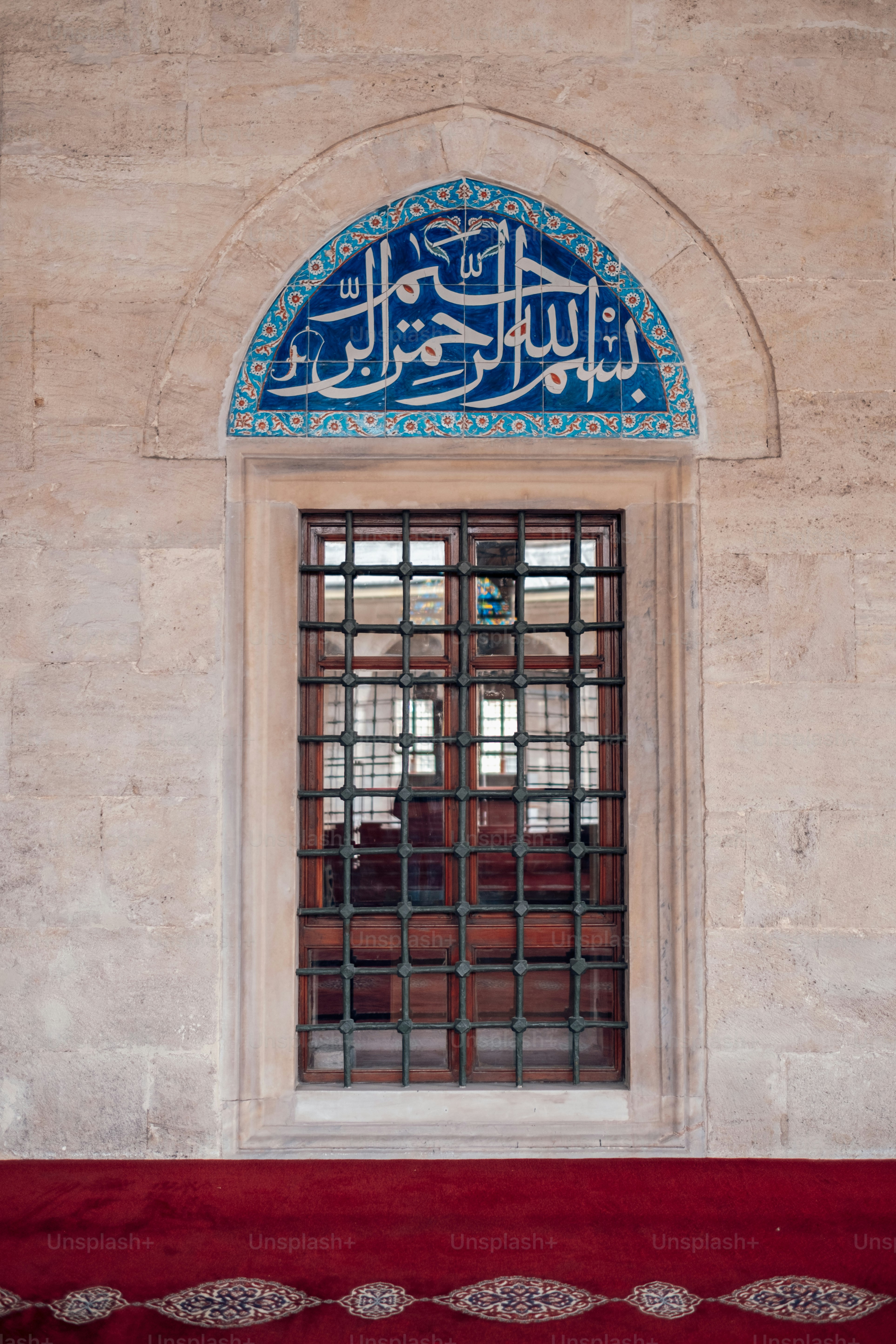 Una ventana en un edificio con una alfombra roja frente a ella