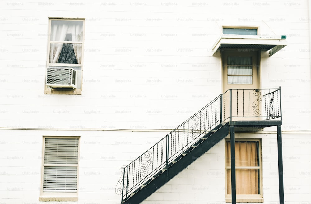 Un edificio blanco con una escalera junto a una ventana