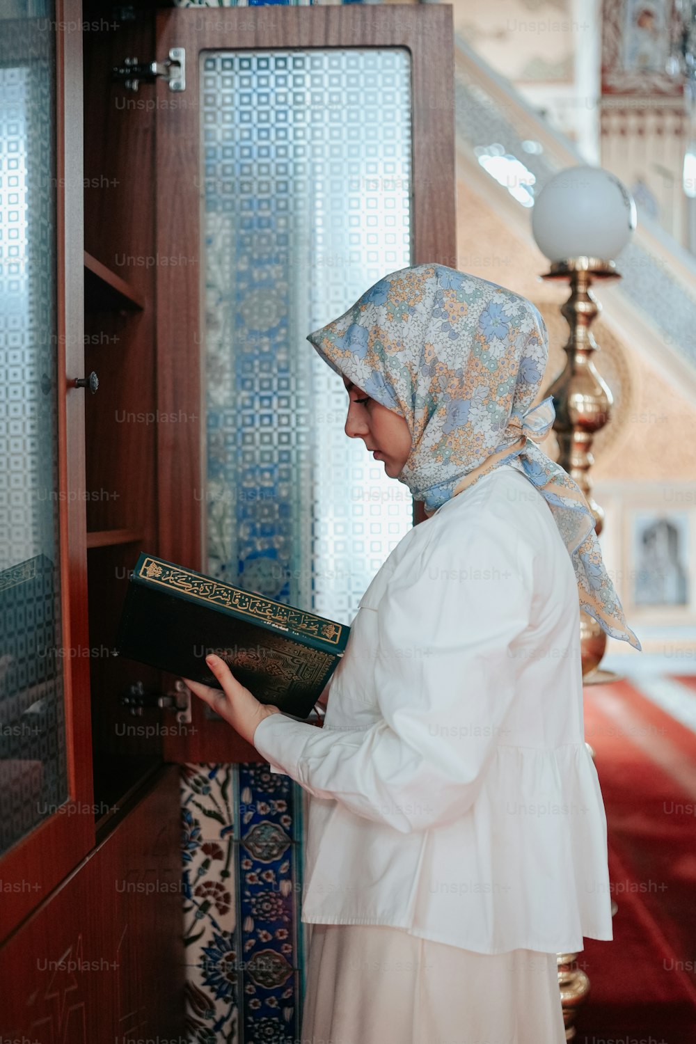 a woman in a headscarf is reading a book