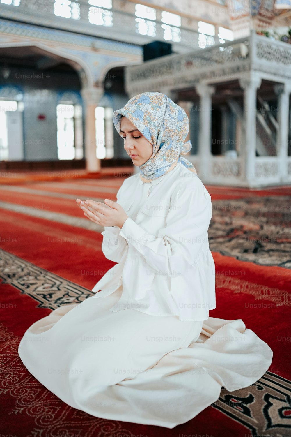 uma mulher em um vestido branco sentado em um tapete