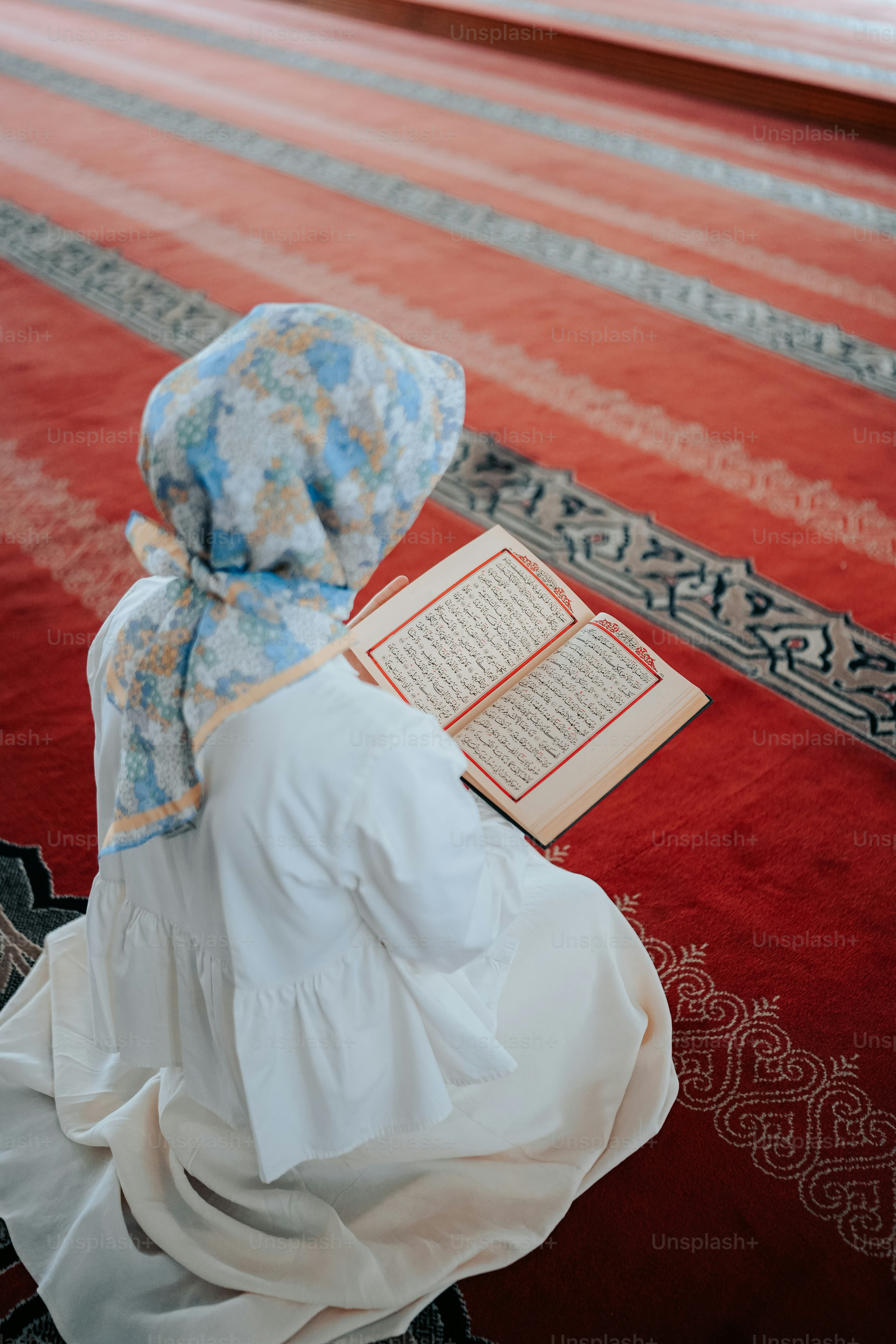 a woman sitting on the floor reading a book