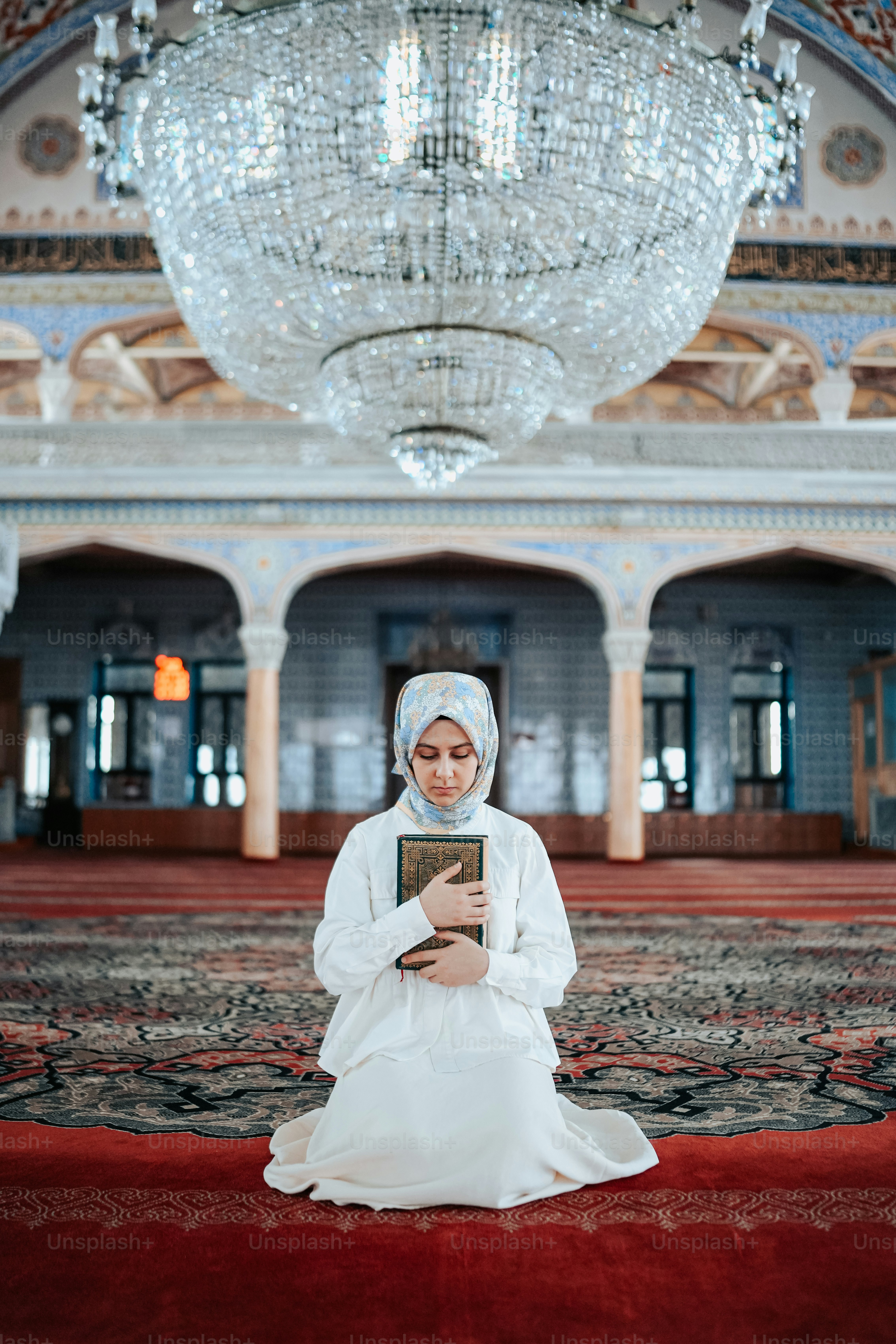 A woman in a white dress sitting on a red carpet photo – Interior ...