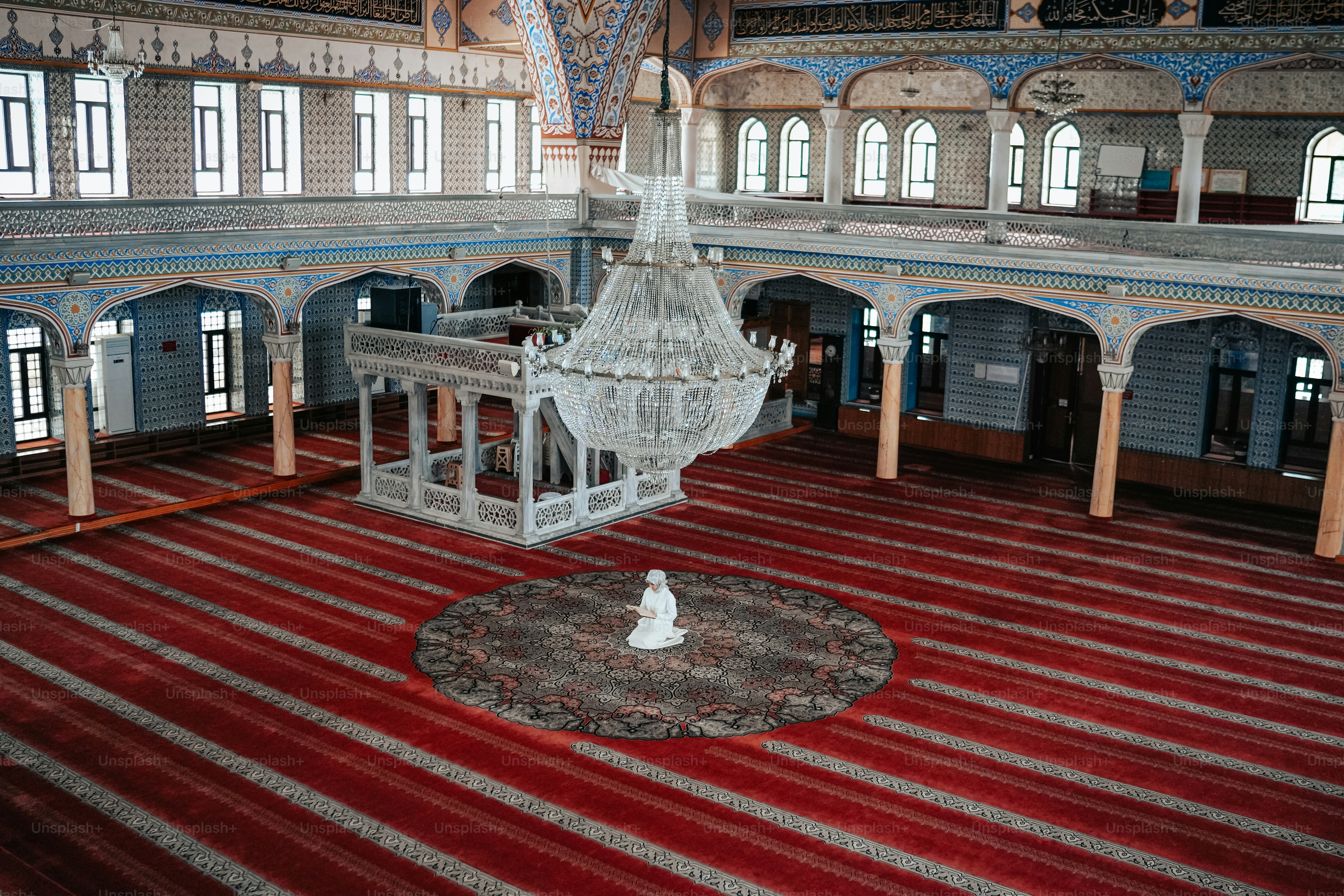 a large room with a red carpet and a chandelier hanging from the ceiling