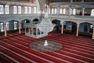 a large room with a red carpet and a chandelier hanging from the ceiling