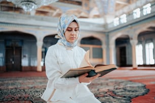 a woman wearing a headscarf reading a book