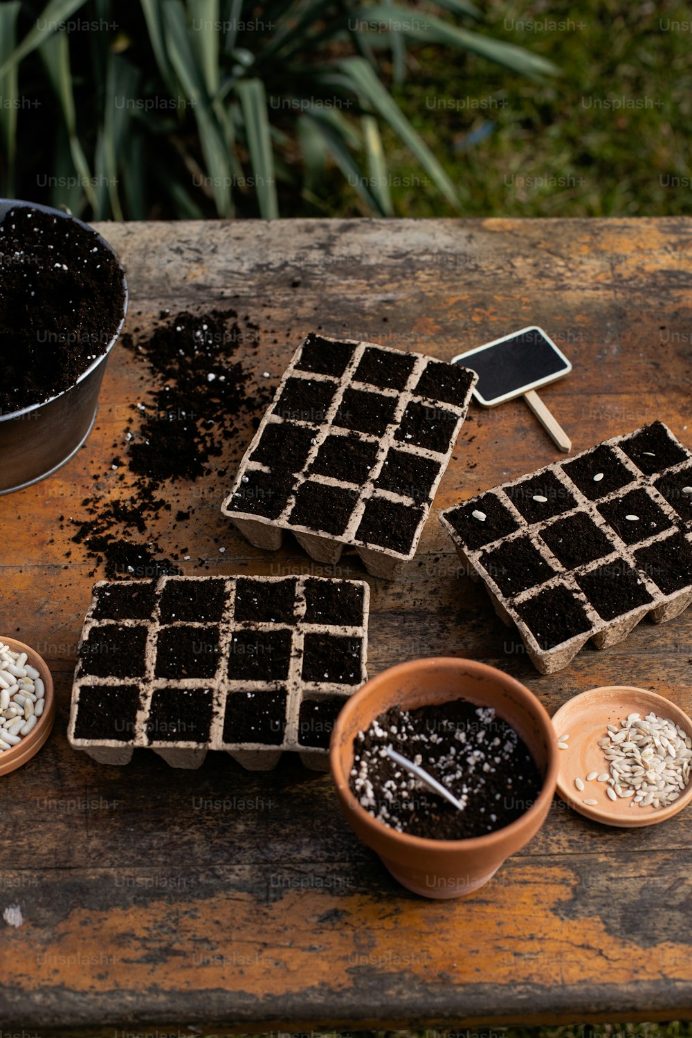 a wooden table topped with chocolate squares and bowls of dirt