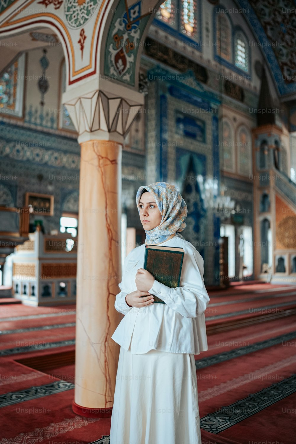 Una mujer con un vestido blanco sosteniendo un libro
