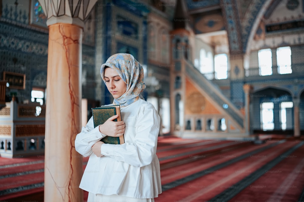 a woman wearing a headscarf is reading a book