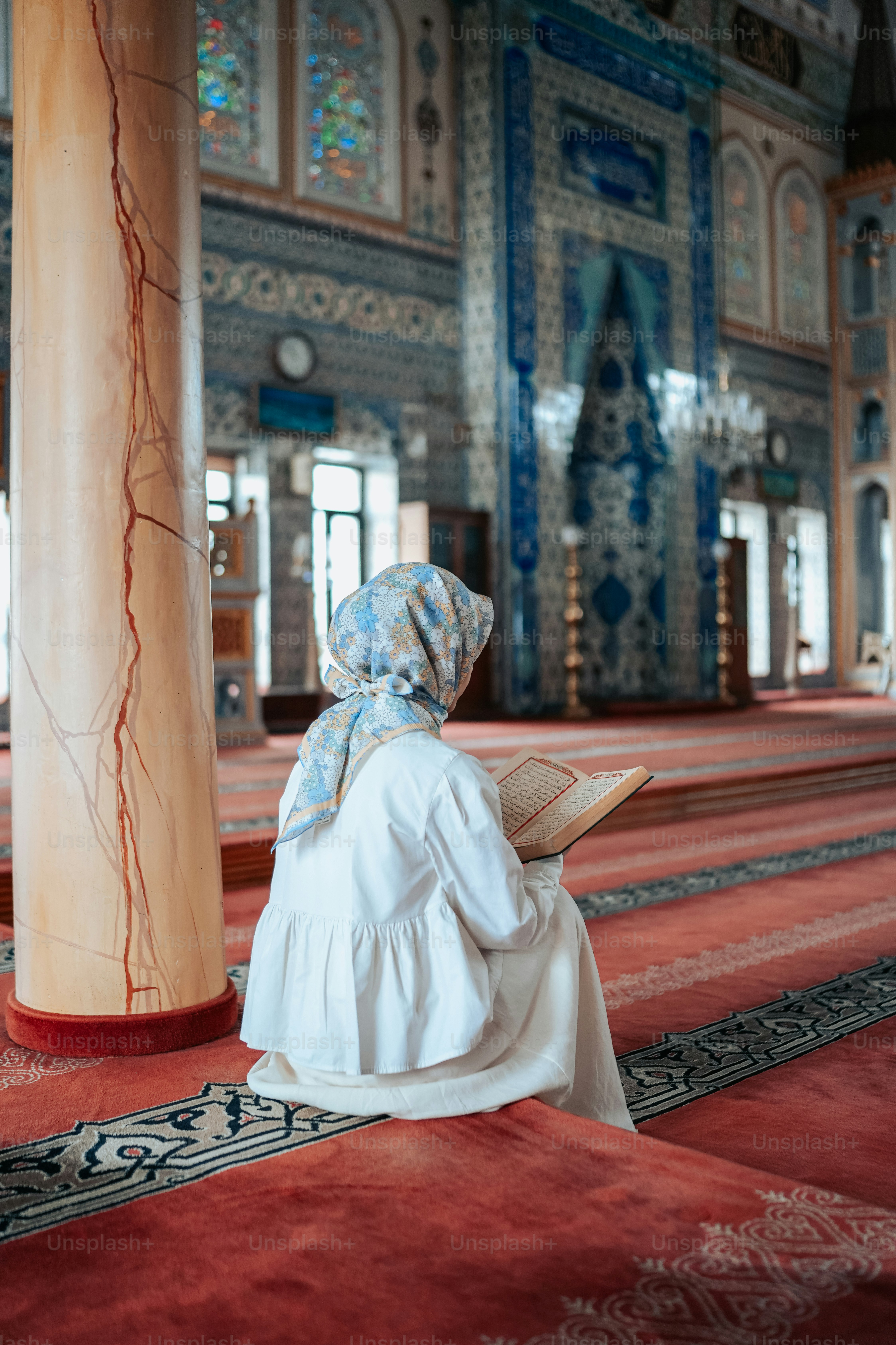 a woman sitting on the floor reading a book