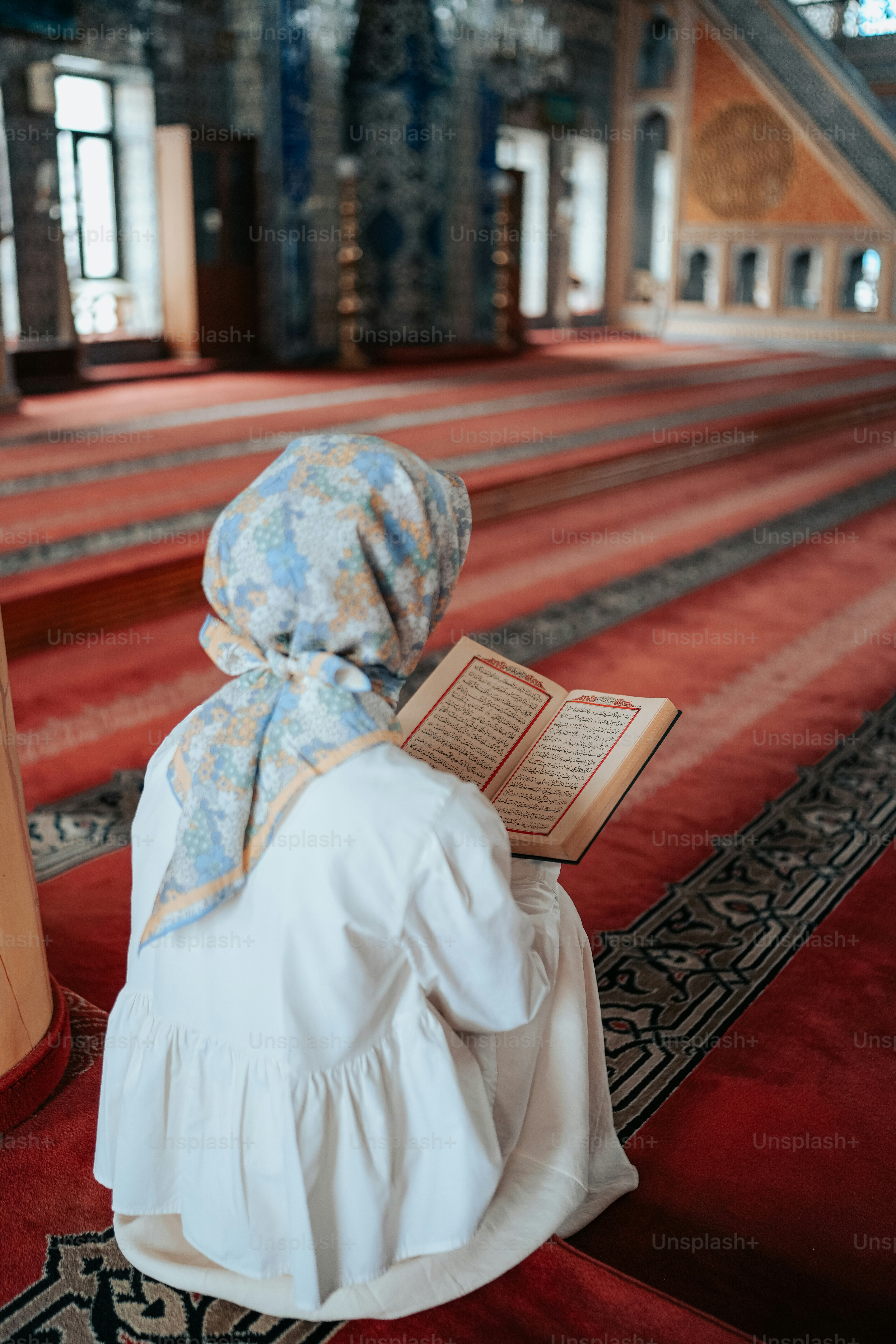a woman sitting on the floor reading a book