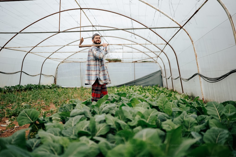 a man standing in a greenhouse with his arms crossed