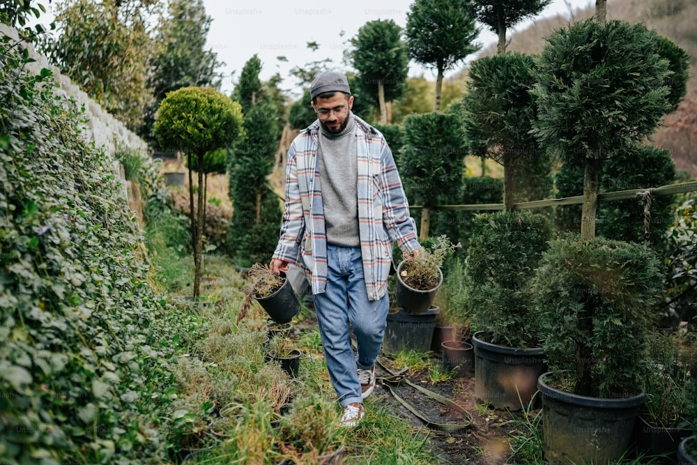 Un homme marchant dans un jardin rempli de plantes en pot