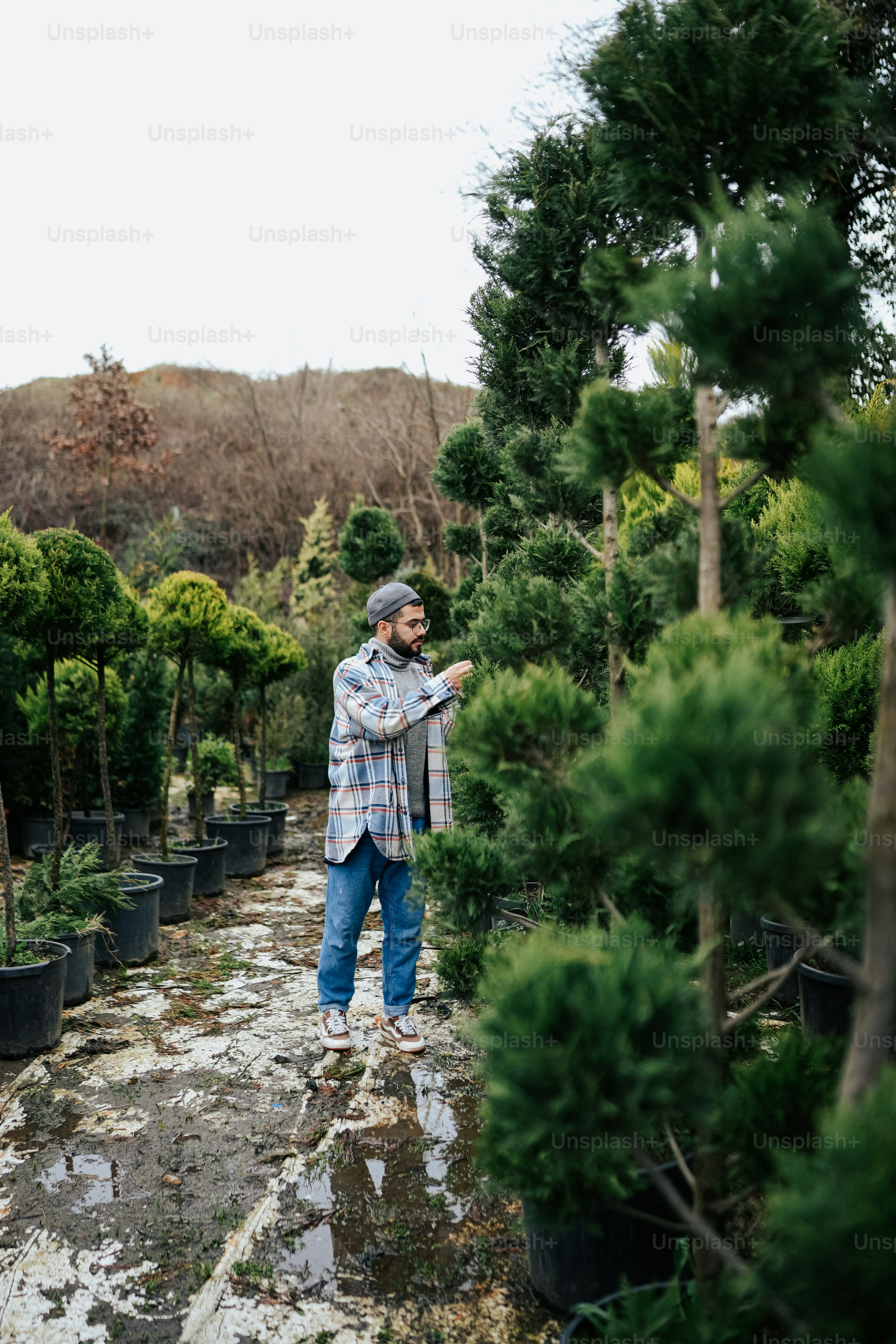 a man standing in a garden center surrounded by trees