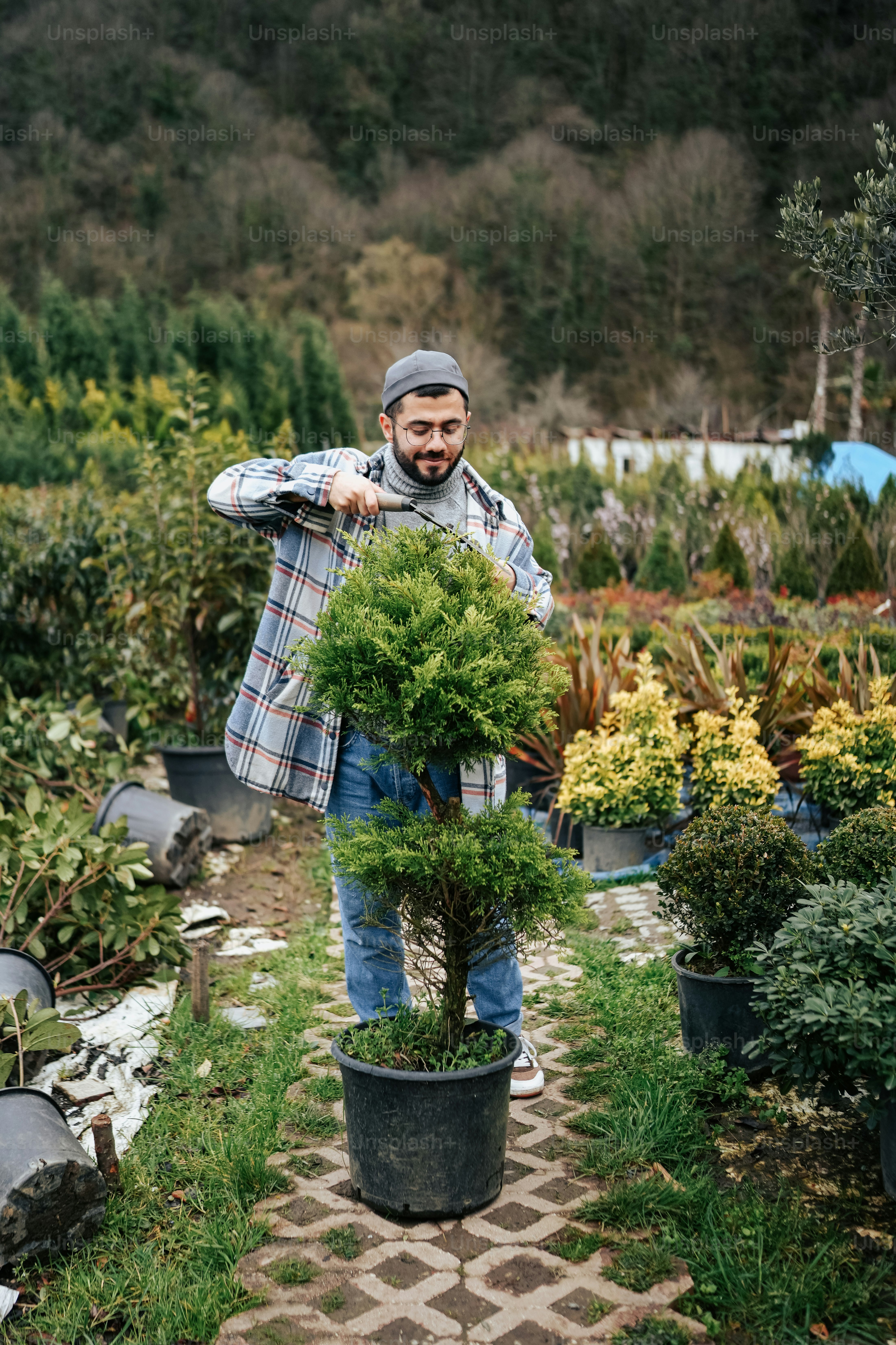 a man holding a potted plant in a garden