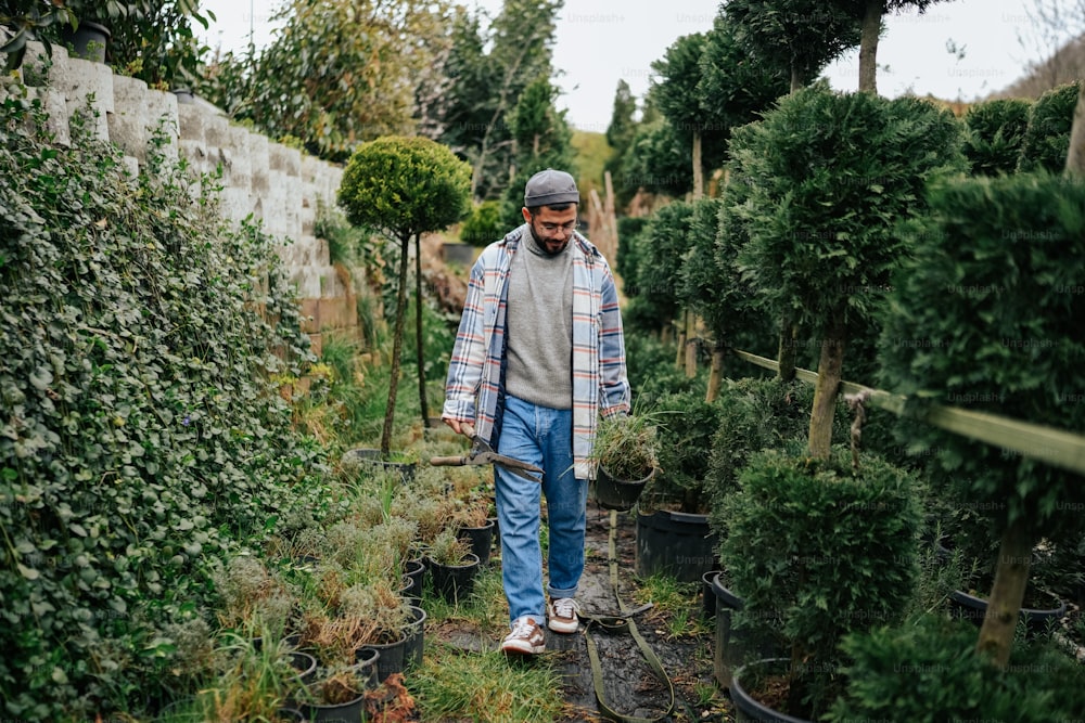 Un hombre caminando por un jardín lleno de plantas en macetas
