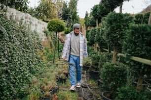 a man walking through a garden filled with potted plants