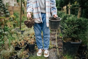 a person standing in a garden holding two buckets