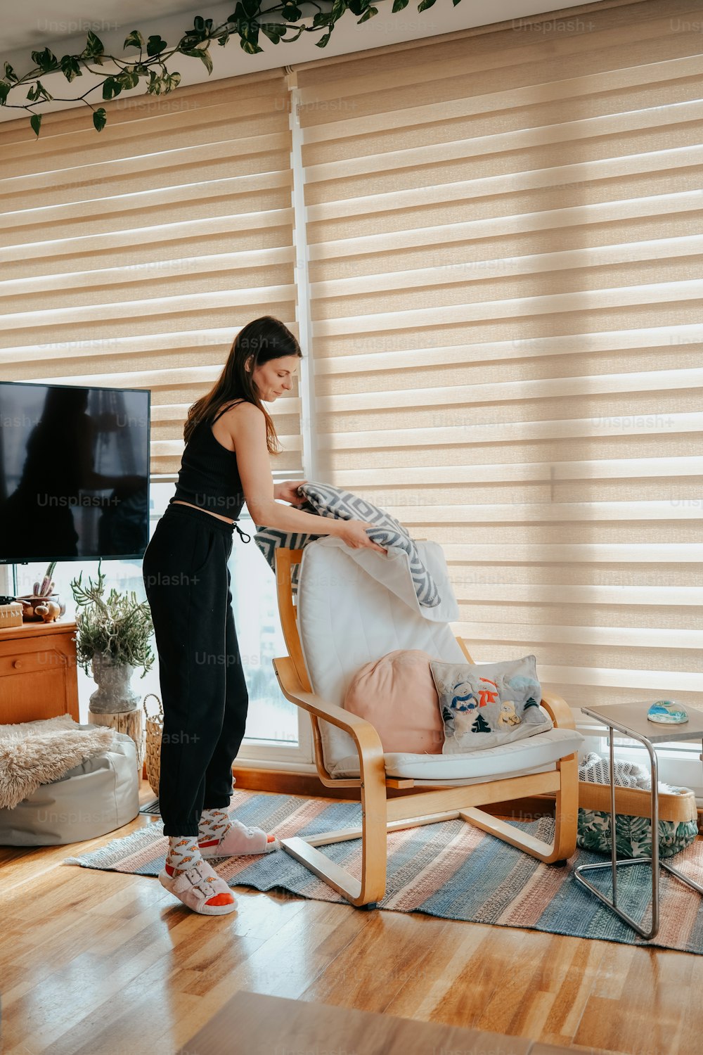 Una mujer planchando una silla en una sala de estar