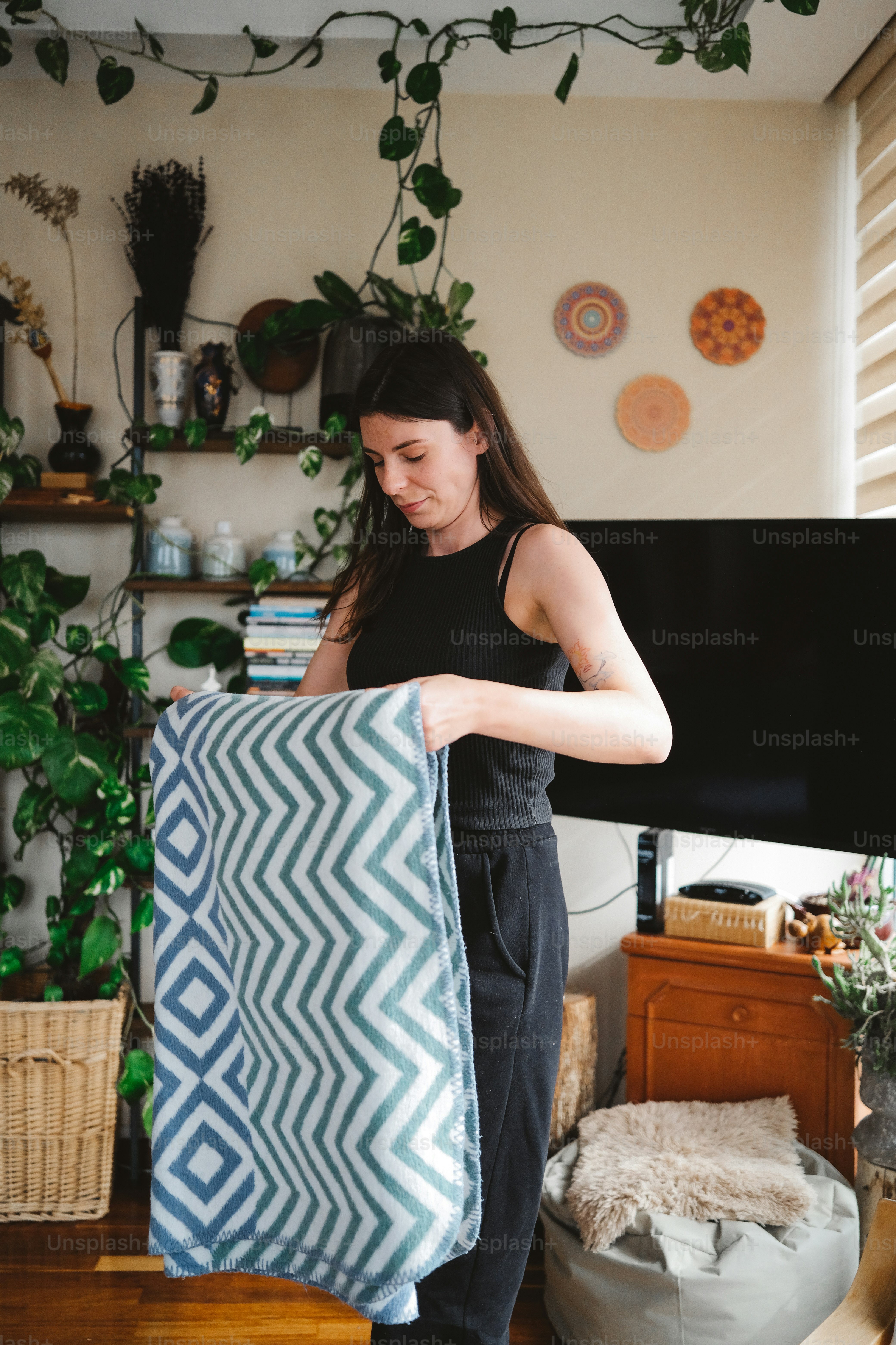 a woman holding a blue and white blanket in a living room