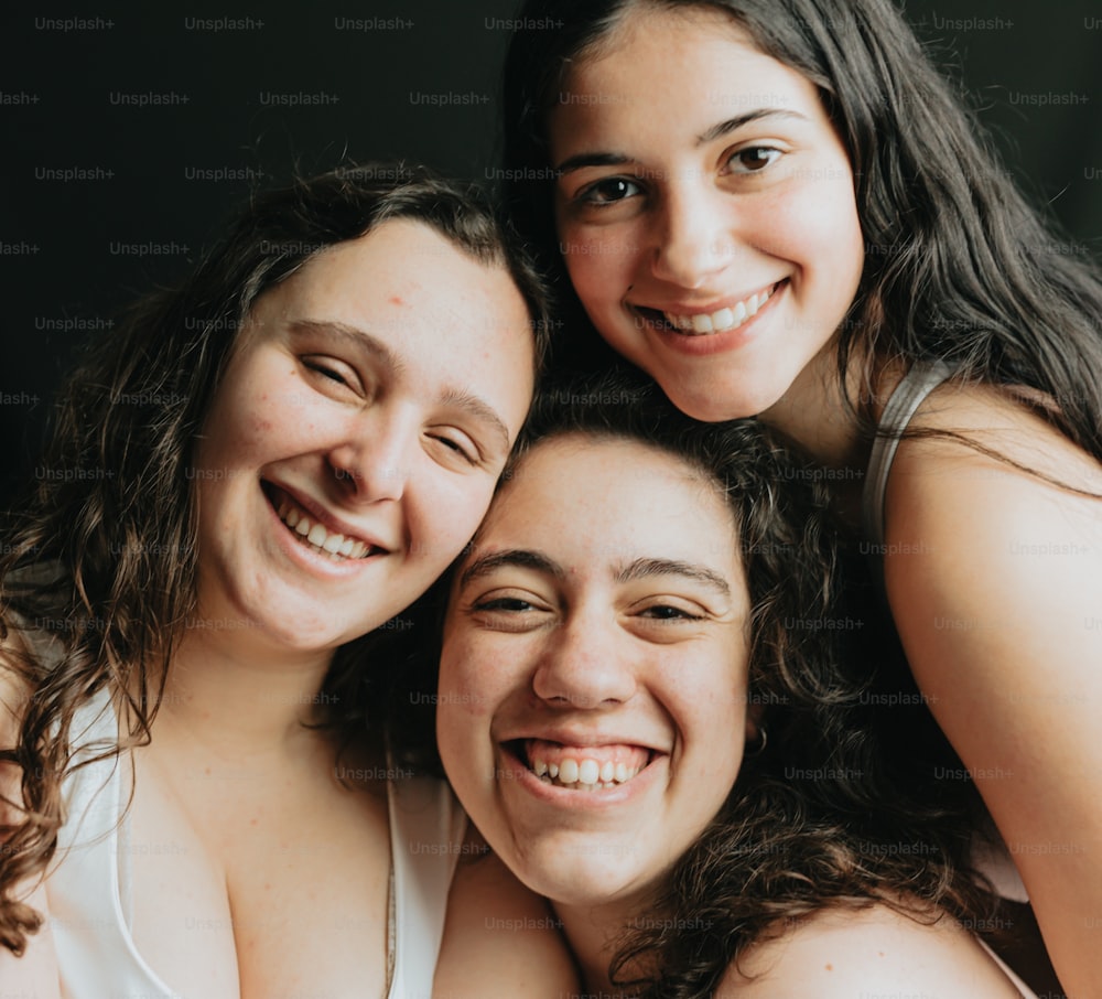 a group of three women standing next to each other