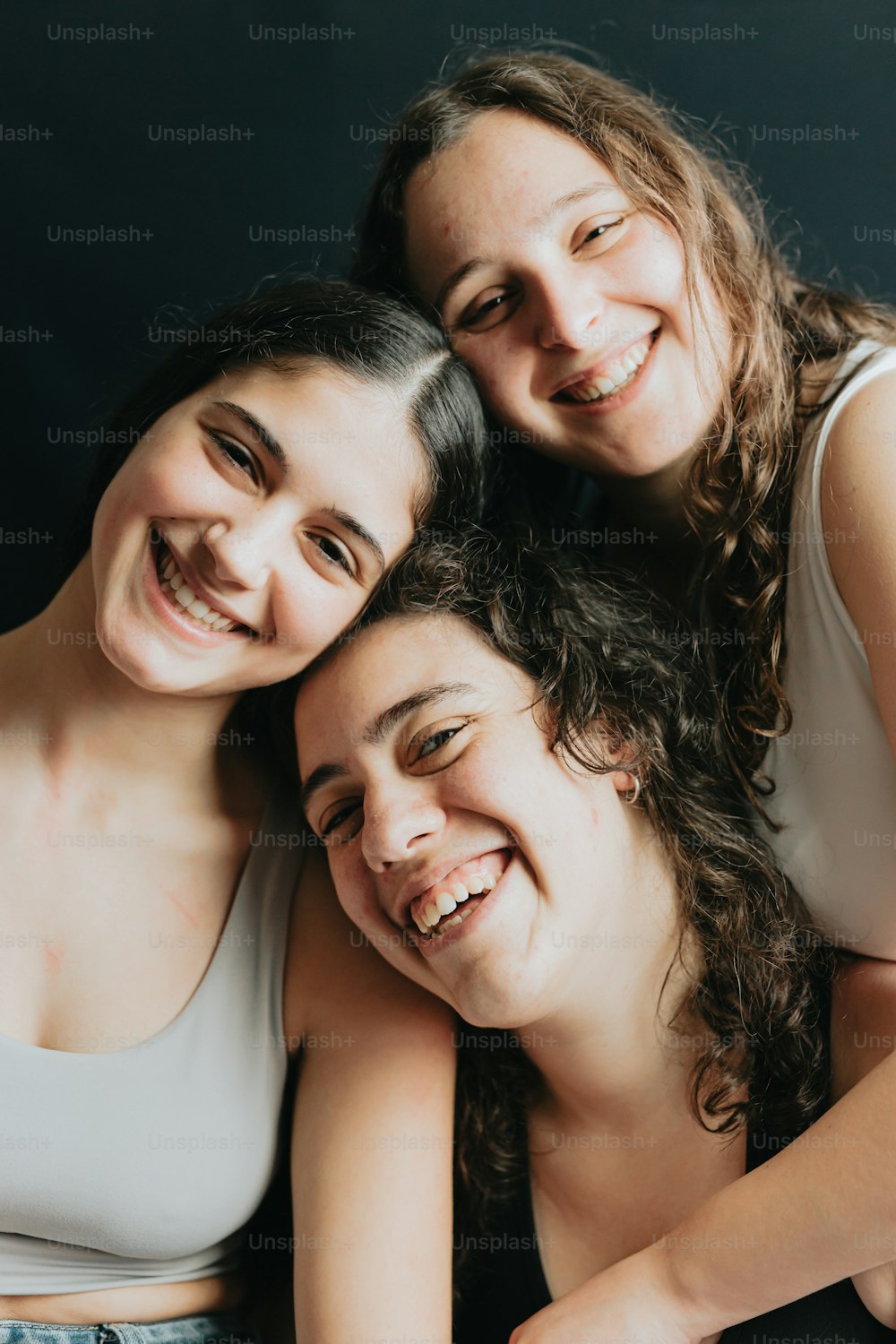 three girls are smiling and posing for a picture