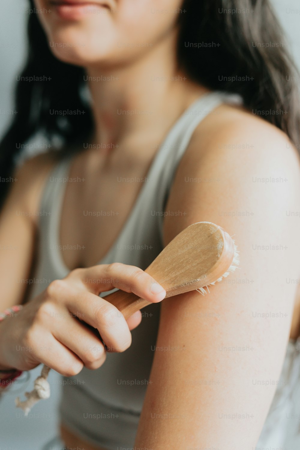 a woman holding a wooden brush with a lot of white stuff on it