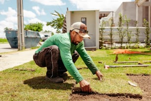 a man in a green shirt is digging in the ground