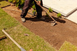Ein Mann mit einer Schaufel gräbt Erde in einem Garten