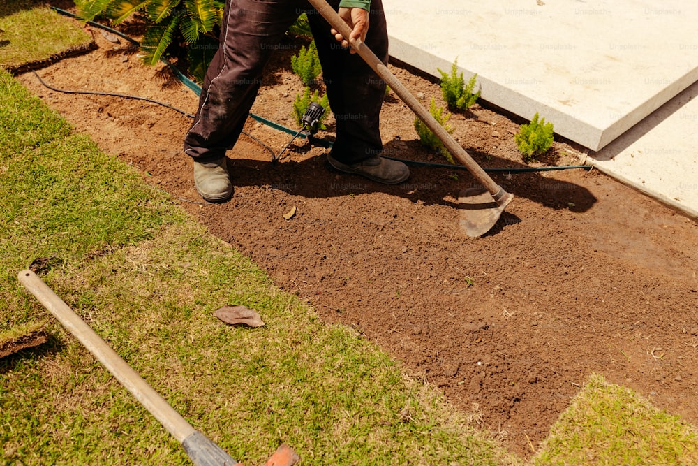 a man with a shovel digging dirt in a garden