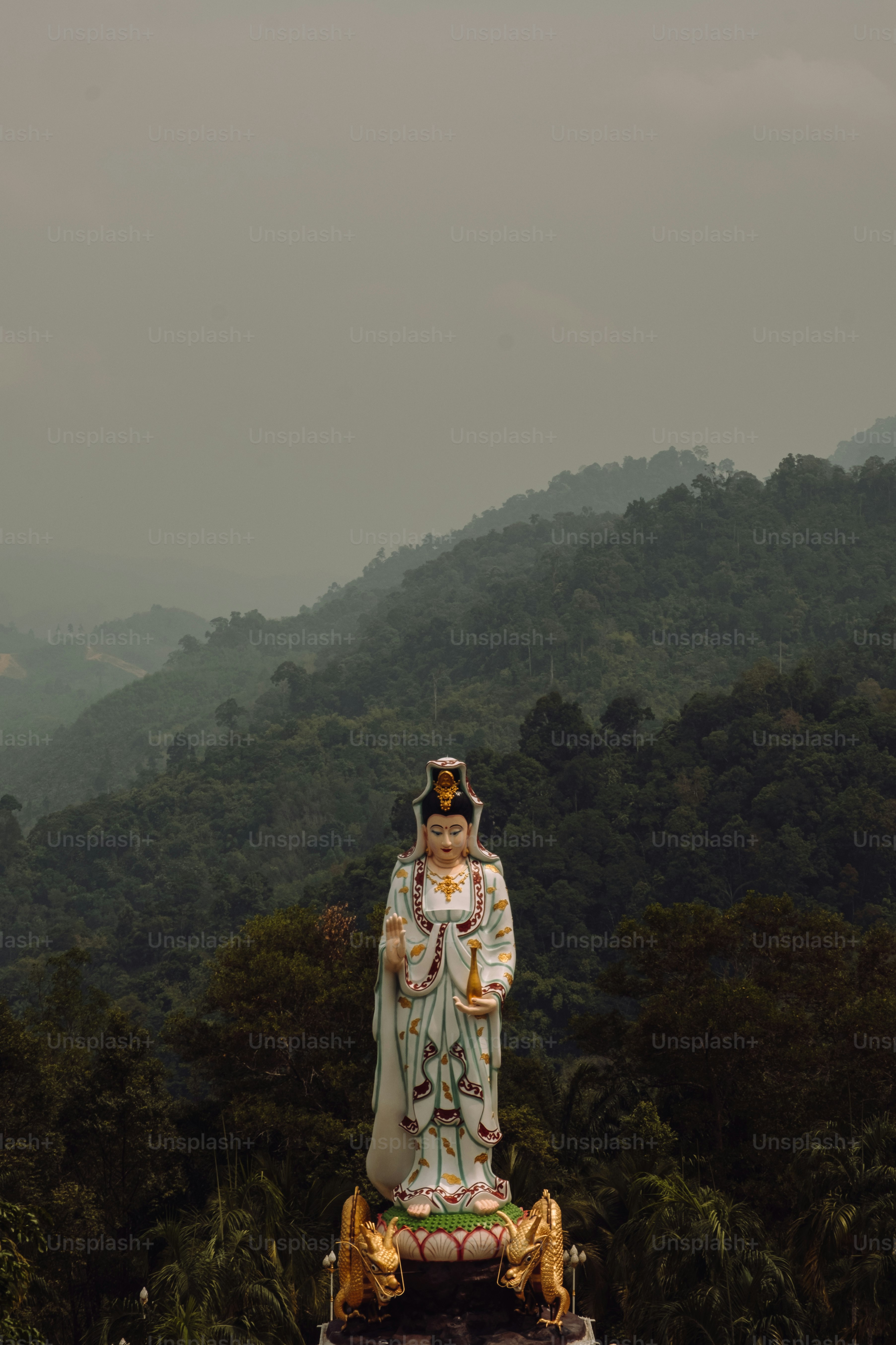 Eine Statue einer Person, die vor einem Berg steht
