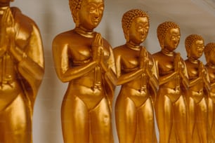a row of golden buddha statues sitting next to each other