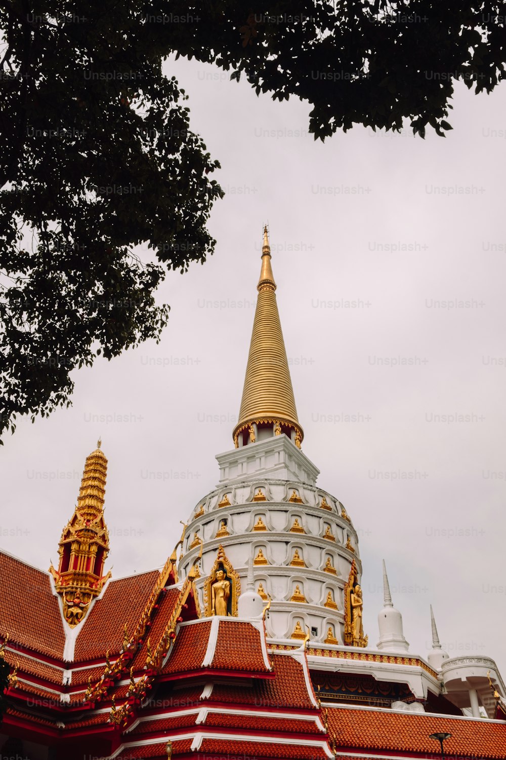 a large white and gold building with a tree in front of it